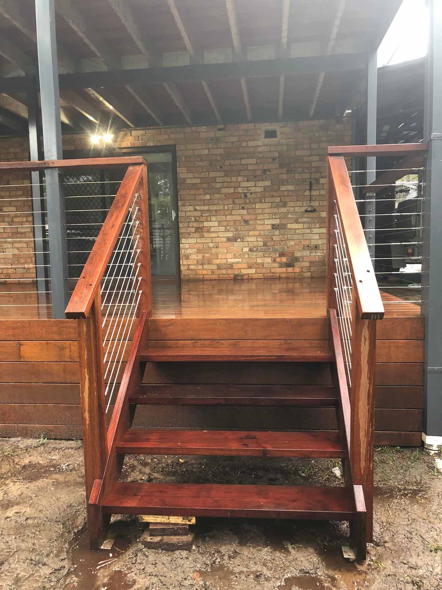 2-about2-rs Timber stairs with wire balustrade leading up to a covered deck