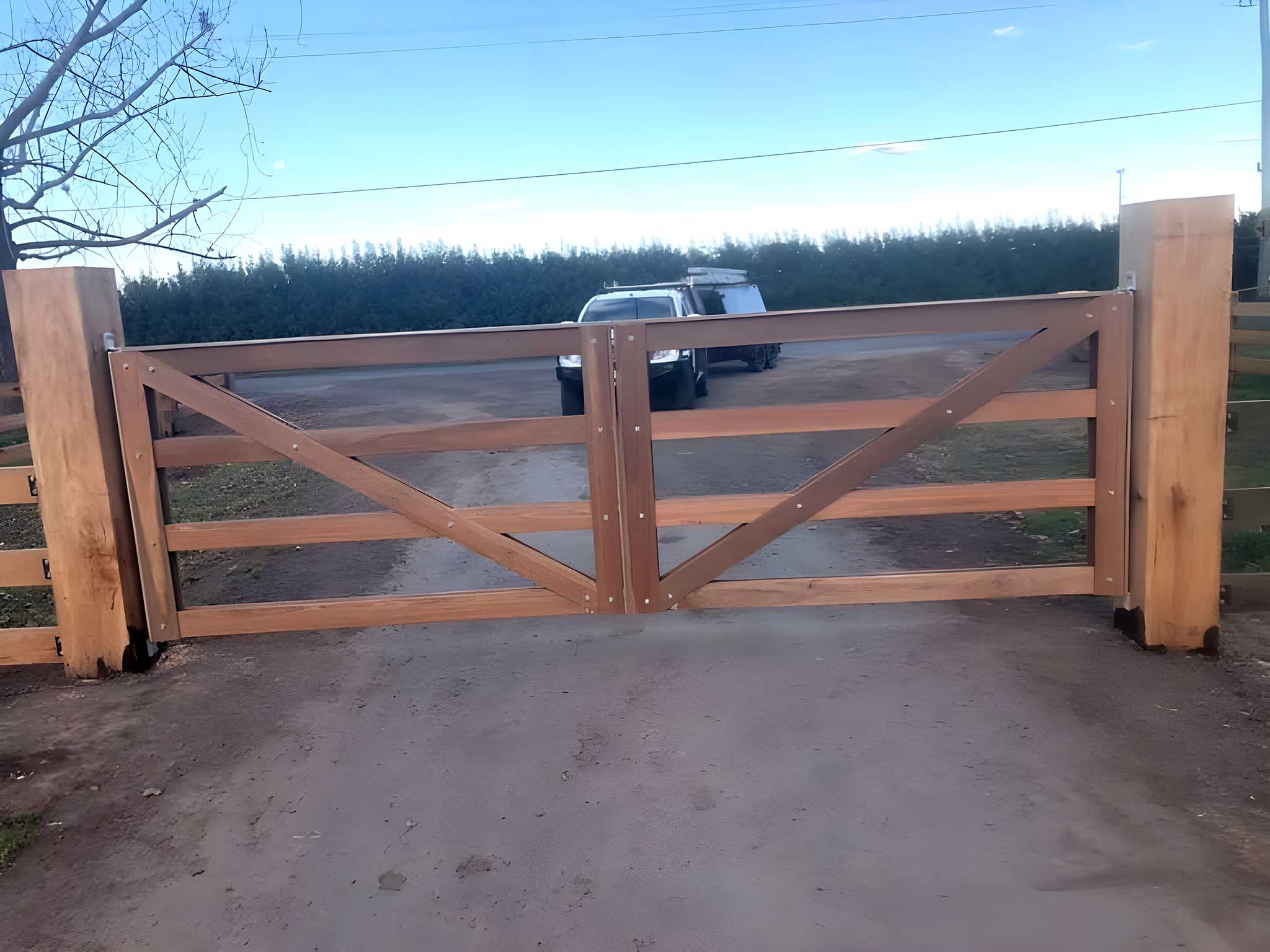 Double timber farm gates hung between large timber posts