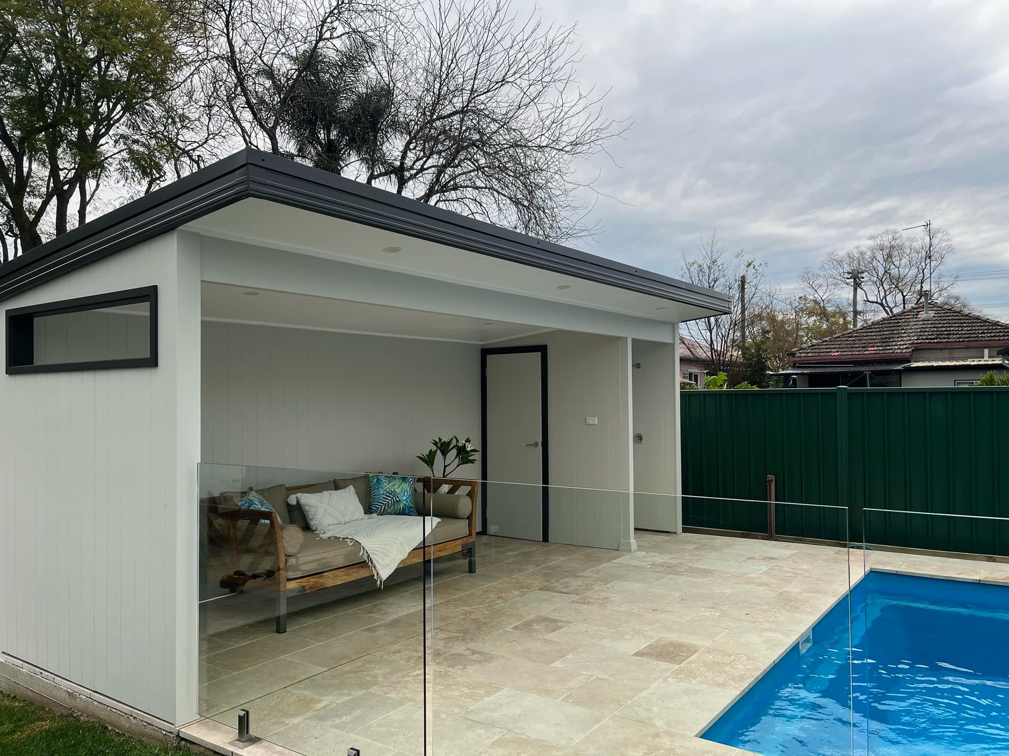 5-pic1 Pool cabana with a daybed behind glass pool fencing